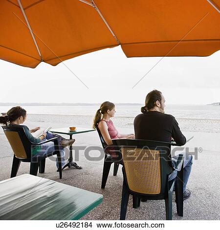 Picture - Man and women sitting at a cafe. Fotosearch