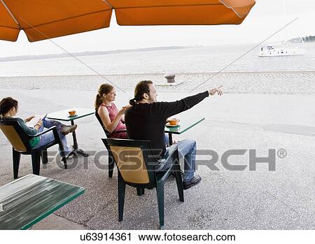 Stock Image - Man and women sitting at a cafe. Fotosearch