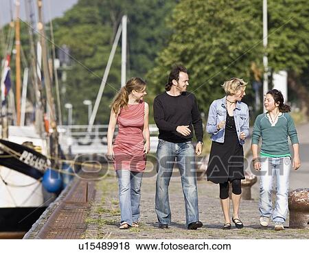 Man and women walking on a pier View Large Photo Image Stock Photo - Man and women walking on a pier. Fotosearch