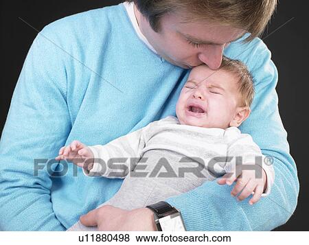 Stock Photo - man comforting screaming baby. Fotosearch