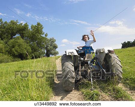 Man driving tractor in field View Large Photo Image Stock Image - Man driving tractor in field. Fotosearch