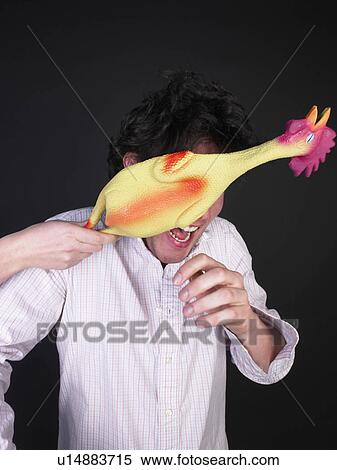 Stock Photography - man getting hit with rubber chicken. Fotosearch