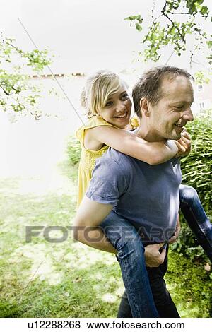 Man giving a girl piggy back ride View Large Photo Image Stock Photo - Man giving a girl piggy back ride. Fotosearch
