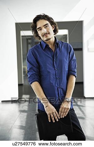 Stock Photograph - Man holding a file, looking at camera. Fotosearch