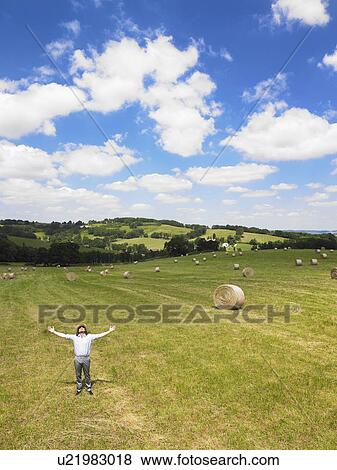 Stock Photo - Man in field with arms open. Fotosearch