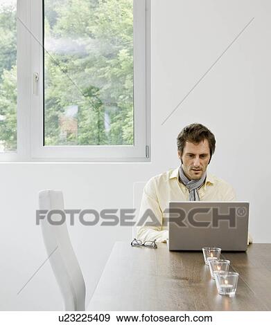 Stock Photo - Man looking at laptop computer. Fotosearch