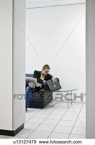 Man looking in briefcase in office View Large Photo Image Stock Photo - Man looking in briefcase in office. Fotosearch