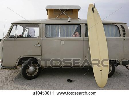 Stock Image - Man looking out of camper van. Fotosearch