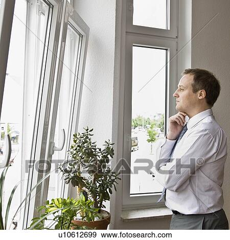 Stock Photo - Man looking out window. Fotosearch
