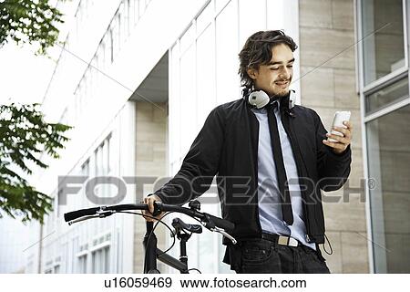 Man next to bicycle, headphones on View Large Photo Image Stock Photo - Man next to bicycle, headphones on. Fotosearch