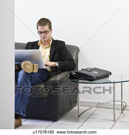 Stock Image - Man on laptop in office. Fotosearch