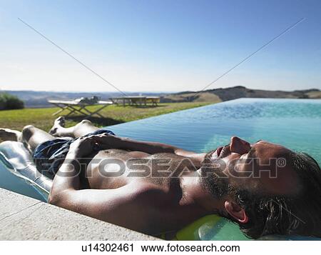 Stock Image - Man resting in swimming pool. Fotosearch