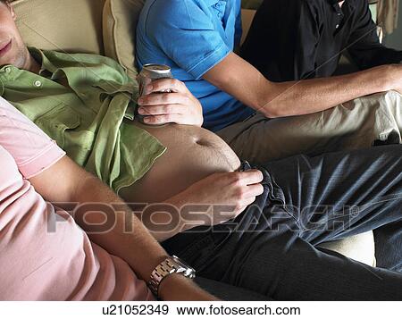 Man showing his stomach, holding a beer View Large Photo Image Stock Photo - Man showing his stomach, holding a beer. Fotosearch
