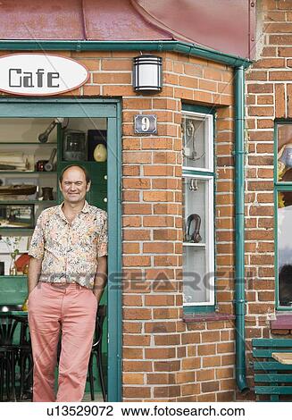 Man standing in front of a cafe View Large Photo Image Stock Image - Man standing in front of a cafe. Fotosearch