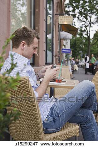 Man text messaging on sidewalk View Large Photo Image Stock Photo - Man text messaging on sidewalk. Fotosearch
