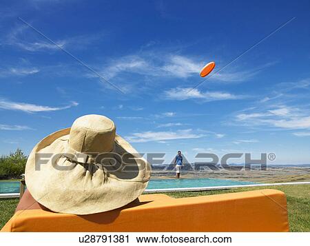 Man throwing Frisbee over pool. View Large Photo Image Stock Image - Man throwing Frisbee over pool.. Fotosearch