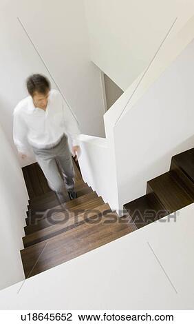 Stock Image - Man walking up the stairs. Fotosearch