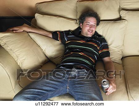 Stock Photo - Man watching television, holding a beer. Fotosearch
