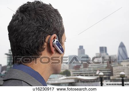 Stock Photo - Man with bluetooth headset outside. Fotosearch