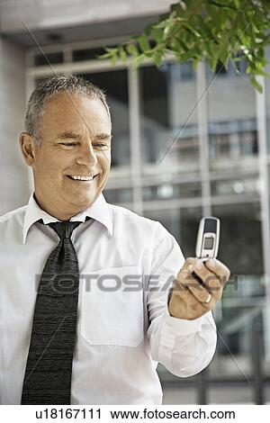 Stock Image - Man with his cellular phone, smiling. Fotosearch