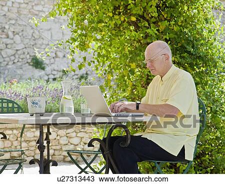 Stock Image - Man working on a laptop computer. Fotosearch