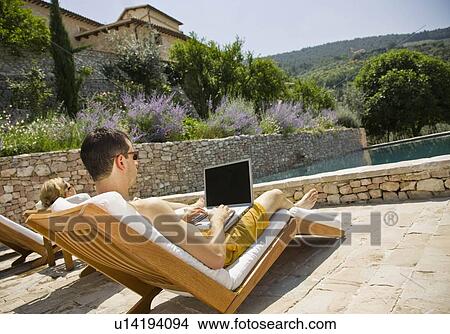 Man working on computer by the pool View Large Photo Image Picture - Man working on computer by the pool. Fotosearch