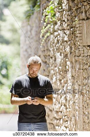 Stock Photo - Man working on his phone. Fotosearch