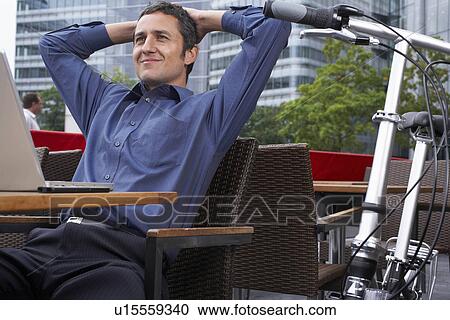 Stock Image - Man working on laptop outside. Fotosearch