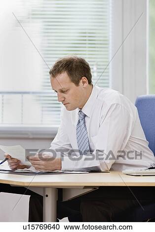 Stock Image - Man working on paperwork. Fotosearch