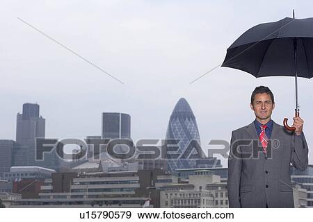 Stock Photo - Mann with umbrella city scape. Fotosearch