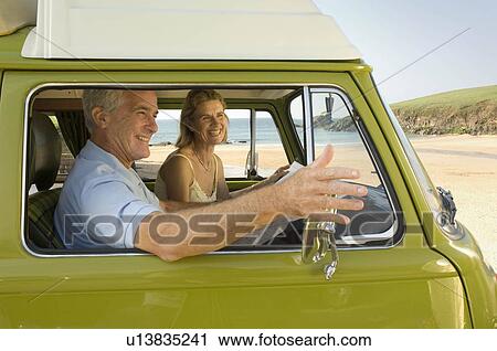 Stock Image - Mature couple in camper van. Fotosearch