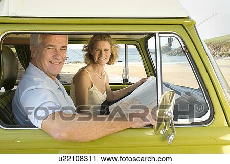 Stock Image - Mature couple in camper van. Fotosearch