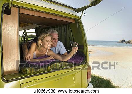 Mature couple lying in camper van View Large Photo Image Stock Photo - Mature couple lying in camper van. Fotosearch