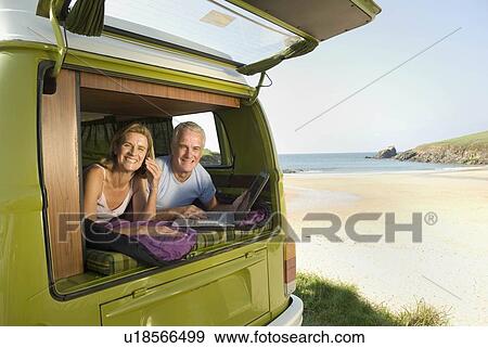Stock Photo - Mature couple lying in camper van. Fotosearch