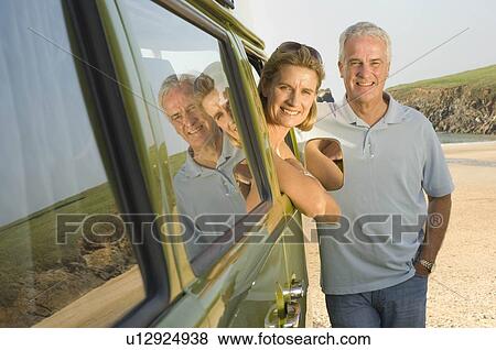 Stock Photo - Mature couple with vintage camper van. Fotosearch