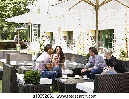 Stock Photography - Men and women talking over drinks. Fotosearch