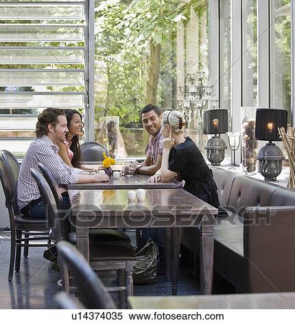 Stock Photography - Men and women talking over drinks. Fotosearch