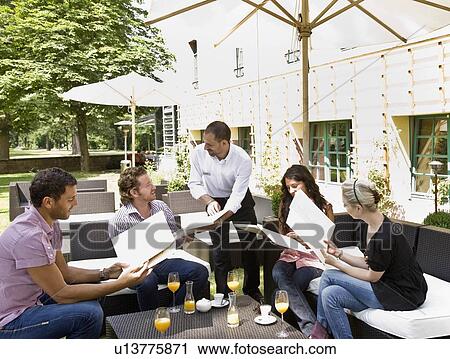 Stock Image - Men and women talking over menus. Fotosearch
