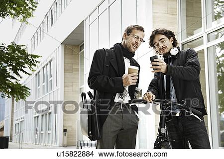 Picture - Men next to bicycle, coffee break. Fotosearch