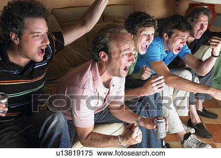 Stock Photography - Men watching television, holding beers. Fotosearch