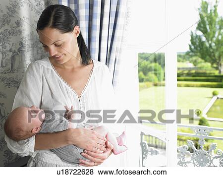Stock Photo - Mother and baby by the window. Fotosearch