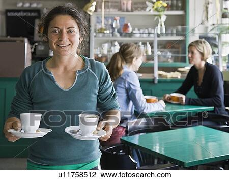 Stock Image - Portrait of a female barista at a cafe. Fotosearch
