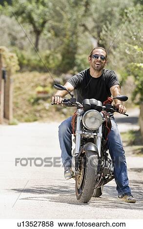 Stock Photo - Portrait of a man on a motorcycle. Fotosearch