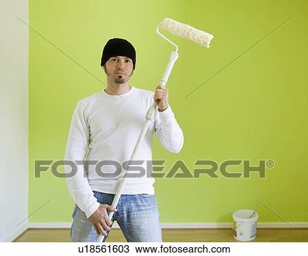 Stock Image - Portrait of a man painting a room. Fotosearch