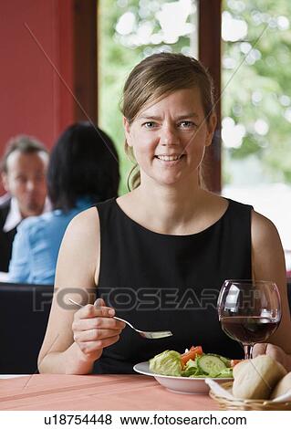 Stock Photo - Portrait of a woman eating a meal. Fotosearch