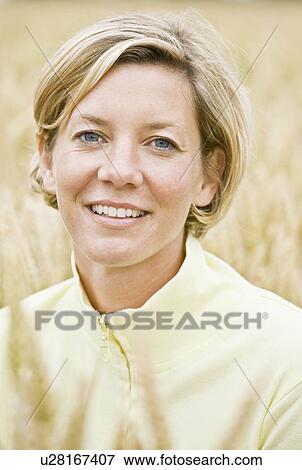 Stock Photo - Portrait of a woman in a field. Fotosearch