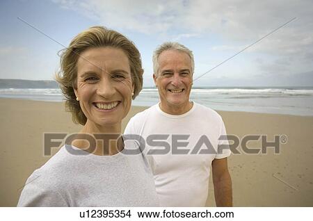 Picture - Portrait of couple smiling on a beach. Fotosearch