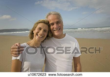Portrait of couple smiling on a beach View Large Photo Image Stock Image - Portrait of couple smiling on a beach. Fotosearch