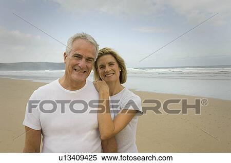 Stock Photography - Portrait of couple smiling on a beach. Fotosearch