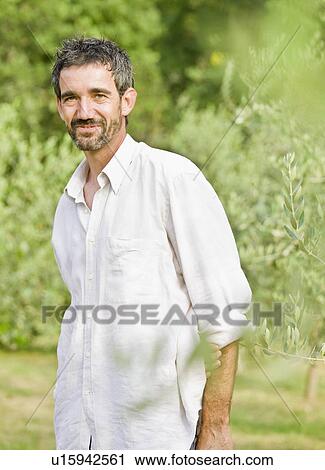 Stock Image - Portrait of man in olive grove. Fotosearch